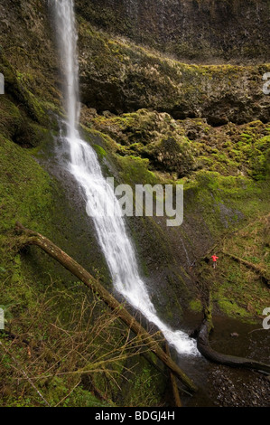 Eine Frau Trail-running-neben einem Wasserfall in Silver Falls State Park, Oregon, USA. Stockfoto