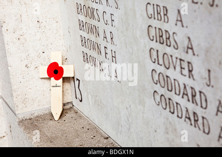 Einsamer Mohn Kreuz links an der Wand mit Namen von vermissten Soldaten in der Gedenkstätte Menin Gate WW1 bei Ypern, Belgien Stockfoto