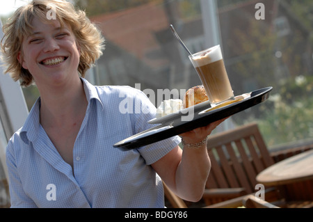 Kellnerin serviert heiße Schokolade und Sahne Dessert zu trinken. Stockfoto