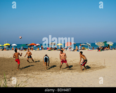 Junge Männer, die Fußball spielen auf Tertenia Strand Stockfoto