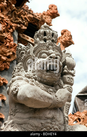 Indonesien, Bali, Kuta, Jalan Pantai, geschnitzten Stein Hindu-Gottheit vor kleinen lokalen Tempel Stockfoto