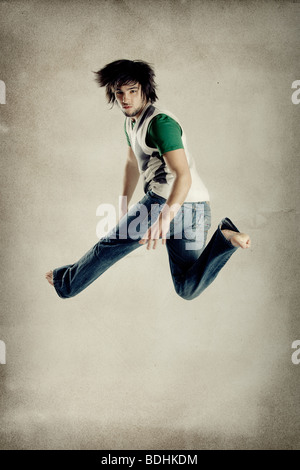 Junge moderne Mensch springen über Grunge Hintergrund Stockfoto