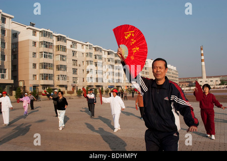 Chinesen führen traditionelle Tai Chi Schwert tanzen und tanzen in einem Quadrat in der Morgendämmerung in De Hui-Stadt, Provinz Jilin, China-Fan. Stockfoto