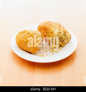 Eine gebrochene Sesam Samen Brötchen auf einem Teller. Stockfoto