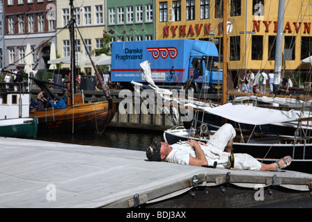 Nachdem eine Pause und eine am Nachmittag Bier in der Sonne auf der Luke eines alten Schiffe in Nyhavn, Hafen die alten Viertel. Stockfoto