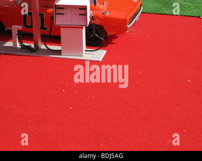 Miniatur-Spielzeugauto an Tankstelle im Freien in der Sonne Stockfoto