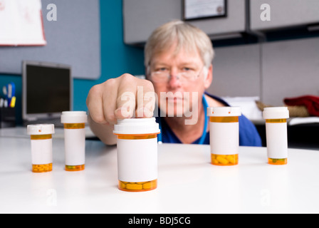 Ein Apotheker wählt die richtige Medikamente für seine Patienten. Etiketten sind leere Kopie auf die Pille Flaschen ermöglichen. Stockfoto