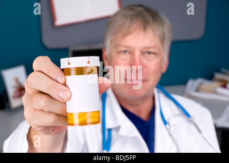 Ein Arzt hält eine Pille Flasche für Rezepte verwendet. Label ist für Kopie leer. Stockfoto