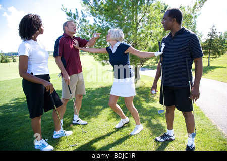 Frau versucht, Break Up Kampf zwischen Golfer Stockfoto