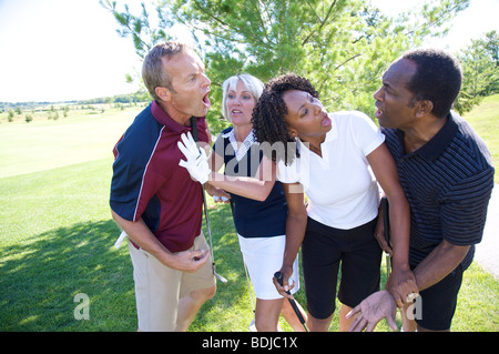 Frauen, die versuchen, Break Up Kampf zwischen Golfer Stockfoto