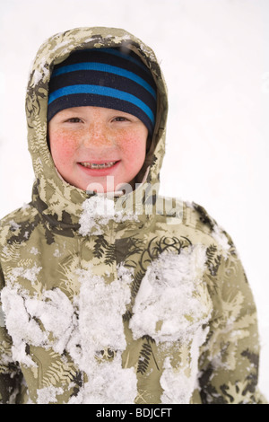 Kleiner Junge spielt im Schnee Stockfoto