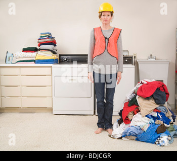 Frau mit Warnweste und Schutzhelm die Wäsche Stockfoto