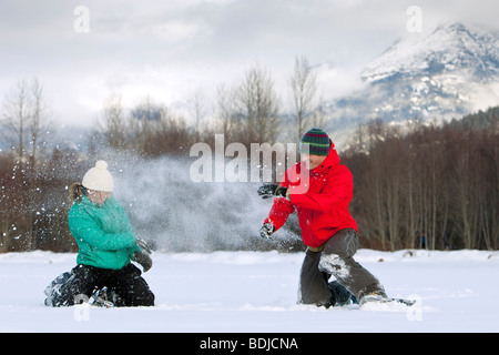 Paar tragen Schneeschuhe haben eine Schneeballschlacht, Whistler, Bristish Columbia, Kanada Stockfoto