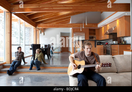 Freunden rumhängen zu Hause, Mann, die Gitarre zu spielen Stockfoto