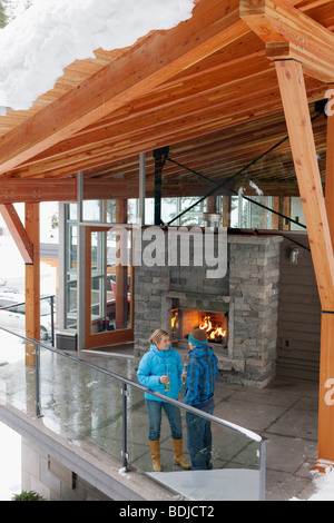 Mann und Frau stehen am Chalet Balkon, Whistler, Britisch-Kolumbien, Kanada Stockfoto