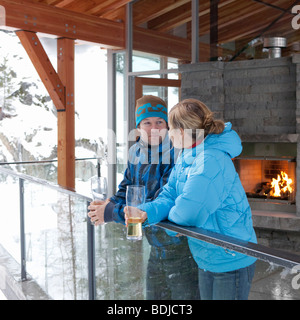 Mann und Frau stehen am Chalet Balkon, Whistler, Britisch-Kolumbien, Kanada Stockfoto