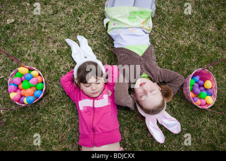 Mädchen liegend neben Osterkörbchen Stockfoto