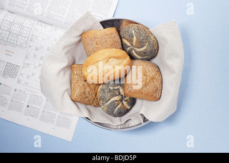 Schüssel mit verschiedenen Brot Brötchen mit Zeitung Stockfoto