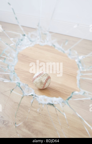 Baseball und zerbrochenes Fenster Stockfoto