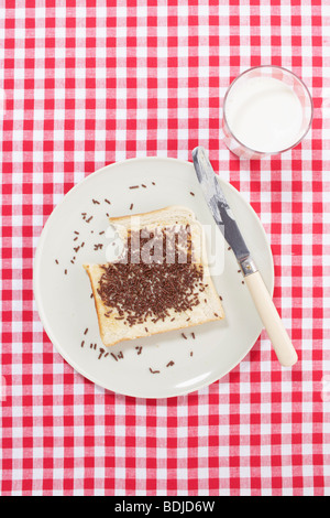 Toast, bestreut mit Schokolade auf Teller mit Glas Milch Stockfoto