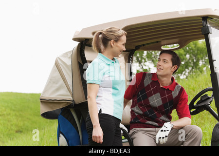 Paar mit Golfwagen auf Golfplatz Stockfoto