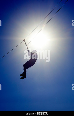 Mann reitet ein Flying Fox, Silhouette gegen Sonne Stockfoto