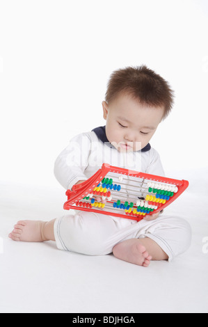 Baby Junge sitzen und spielen mit einem Spielzeug Abakus, Kind Stockfoto