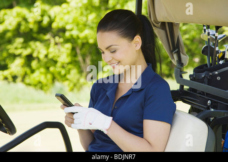 Frau im Golf-Cart Stockfoto