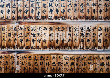 Holztafeln mit japanischer Schrift auf dem Display vor einem Tempel in Kyoto, Japan Stockfoto