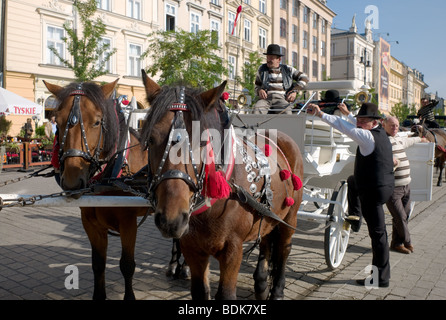 Pferdekutschen warten auf Kunden auf dem Hauptplatz der polnischen Stadt Krakau Stockfoto