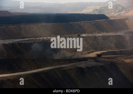 EIN TAI BAO MINE, Provinz SHANXI, CHINA - AUGUST 2007: LKW werfen Staub wie sie Kohle aus dieser riesigen Tagebau-Mine sammeln Stockfoto