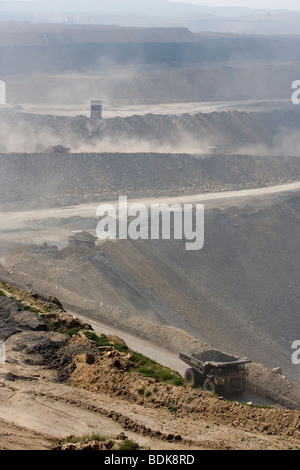 EIN TAI BAO MINE, Provinz SHANXI, CHINA - AUGUST 2007: LKW werfen Staub wie sie Kohle aus dieser riesigen Tagebau-Mine sammeln Stockfoto