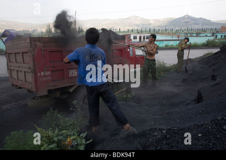 DATONG, Provinz SHANXI, CHINA - AUGUST 2007: Jungen im Teenageralter laden Kohlenstaub auf einen LKW am Straßenrand. Stockfoto