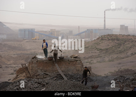 WUDA COAL FIELD, WU HAI, Innere Mongolei, CHINA - AUGUST 2007: Liang Yan Fa trägt Körbe gesiebte Kohle, Schwefel zu machen. Stockfoto