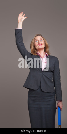 Glücklich Geschäftsfrau stehen und winken ihren arm Stockfoto