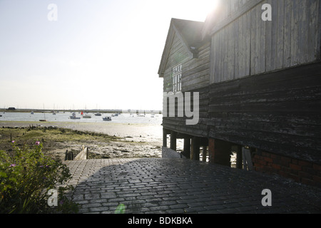 Slipanlage Mersea Island. Kleines Boot an der Mündung der Blackwater, Sonne bricht über das Steildach wirft einen Schatten werfen Stockfoto