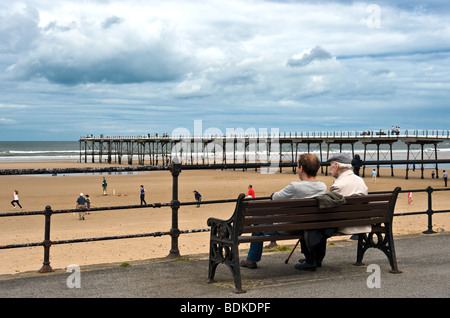 Vater und Sohn saß auf der Bank am Meer Stockfoto