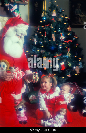 Jolly altes St. Nick junge Mädchen Baby präsentiert Weihnachtsbaum Morgen Kamin Stockfoto