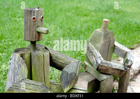 Holzfiguren sitzen in der Nähe von Garten Rasen England UK Stockfoto