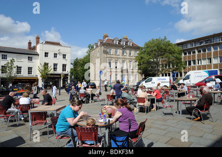 Leute sitzen draußen bei Lloyds-Café-Tischen genießen al fresco Sommersonnenschein Market Square Warwick England Stockfoto