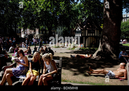 Menschen versammeln, um entspannen in der Sonne um die Mittagszeit in Soho Square (auch bekannt als Soho Beach) im Zentrum von London. Stockfoto