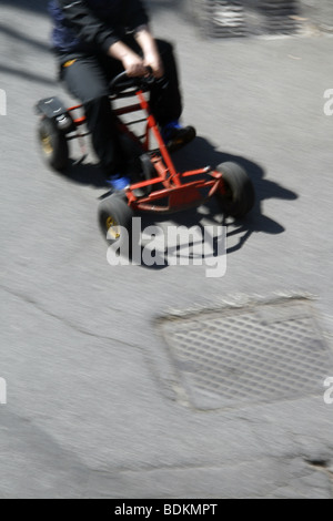 junge Reiten schnell gehen Kart-Auto in der Straße im park Stockfoto