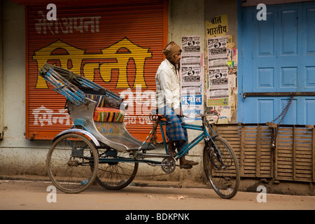 Ein Zyklus-Rikscha-Fahrer wartet auf Benutzerdefiniert auf einer Straße in Varanasi, Indien. Stockfoto