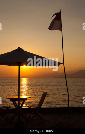 Indonesien, Lombok, Gili Air, Gusung Indah Resort, Tisch im Restaurant direkt am Meer mit Blick auf die Lagune bei Sonnenuntergang Stockfoto