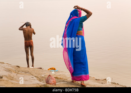 Eine Frau in einen Sari und ein Mann Baden an den Ufern des Flusses Ganga (Ganges) in Varanasi, Indien. Stockfoto