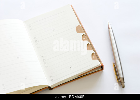 Adressbuch mit Silberstift isoliert auf weißem Hintergrund Stockfoto