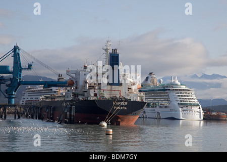 Seward, Alaska - das Schiff braucht Rapier auf eine Last von Kohle umgeben von Kreuzfahrtschiffen im Hafen von Seward. Stockfoto