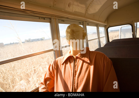 Mannequin gekleidet in der Kleidung des Gefangenen, Reiten in einem Schulbus, aufgegeben, Feld, Mais, Bauernhof, gruselig, Halloween-Ausstellung Stockfoto