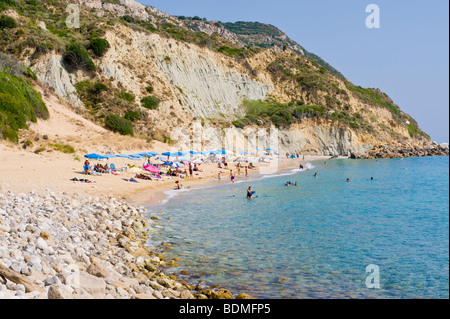 Touristen nehmen Sie ein Sonnenbad unter Klippen am Strand von Koroni auf der griechischen Mittelmeer Insel von Kefalonia Griechenland GR Stockfoto