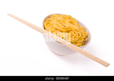 Ess-Stäbchen, Schüssel und Nudeln auf weißem Hintergrund Stockfoto
